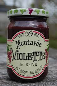 Un pot de moutarde violette de Brive, avec une étiquette vintage indiquant sa préparation au moût de raisin, illustrant un condiment traditionnel français en bocal.